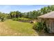 Sprawling backyard area with rustic wood patio, deck, and tropical plants at 538 Murray St, Osteen, FL 32764