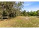 Inviting backyard featuring a peaceful bench under a shaded tree, ideal for relaxation and quiet contemplation at 538 Murray St, Osteen, FL 32764
