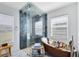 Modern bathroom boasts a spacious glass shower and clawfoot tub, filled with natural light at 538 Murray St, Osteen, FL 32764