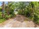 Gravel driveway leading to home surrounded by mature trees and landscaping at 538 Murray St, Osteen, FL 32764