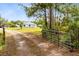 Gated driveway entrance with home in background surrounded by trees at 538 Murray St, Osteen, FL 32764