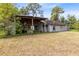 Rustic home exterior featuring a wooden porch and adjacent storage area at 538 Murray St, Osteen, FL 32764