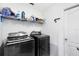 Functional laundry room featuring modern Samsung washer and dryer units, along with storage shelving and a side entry door at 538 Murray St, Osteen, FL 32764