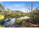 Picturesque pond view from a deck, with lush green grass and trees reflecting in the calm water under a blue sky at 538 Murray St, Osteen, FL 32764