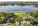 Stunning aerial view of a lakefront home, showcasing the sparkling pool, lush landscaping, and serene lake at 5527 Sandalwood Dr, Orlando, FL 32839