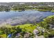 Picturesque aerial view captures the stunning lake reflecting the sky with beautiful homes and lush greenery at 5527 Sandalwood Dr, Orlando, FL 32839