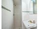 Clean bathroom featuring white tiles, a pedestal sink, and a shower, offering a functional and bright space at 5527 Sandalwood Dr, Orlando, FL 32839