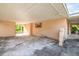 Covered carport area with concrete flooring and view of green trees in yard at 5527 Sandalwood Dr, Orlando, FL 32839