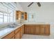 Functional kitchen boasts ample counter space, wood cabinetry, and a double stainless steel sink beneath window at 5527 Sandalwood Dr, Orlando, FL 32839