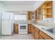 Well-lit kitchen equipped with white appliances, wood cabinetry, and white countertops at 5527 Sandalwood Dr, Orlando, FL 32839