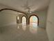 Spacious living room featuring tiled flooring, arched brick openings, and natural light from a window at 5527 Sandalwood Dr, Orlando, FL 32839