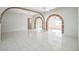 Spacious living room featuring white tile floors and brick archways, creating an open and airy atmosphere at 5527 Sandalwood Dr, Orlando, FL 32839