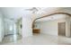 Bright living room boasts white tile floors and brick archways, flowing into additional rooms, perfect for entertaining at 5527 Sandalwood Dr, Orlando, FL 32839