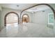 Bright living room featuring brick arches, white tile floors, and neutral walls, offering a spacious and airy feel at 5527 Sandalwood Dr, Orlando, FL 32839