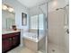 Bathroom features a glass enclosed shower and tub with updated fixtures and decor at 5852 Stafford Springs Trl, Orlando, FL 32829