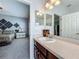 Bathroom with a large mirror above the vanity and an open doorway to the bedroom at 5852 Stafford Springs Trl, Orlando, FL 32829