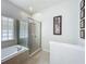 Bright bathroom features a glass enclosed shower and tub with decorative tiled flooring at 5852 Stafford Springs Trl, Orlando, FL 32829