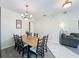 Well-lit dining area features a wood table with seating for six and modern chandelier at 5852 Stafford Springs Trl, Orlando, FL 32829