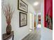 Hallway featuring modern decor, wood-look floors, and access to the kitchen and other areas of the home at 5852 Stafford Springs Trl, Orlando, FL 32829
