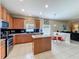 Spacious kitchen with warm wood cabinetry, center island, and eat in kitchen area at 5852 Stafford Springs Trl, Orlando, FL 32829