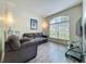 Cozy living room features wood floors, natural light, and comfortable gray couches at 5852 Stafford Springs Trl, Orlando, FL 32829