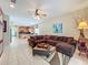 Open-concept living room with a large sectional sofa and seamless transition to the kitchen and dining areas at 5852 Stafford Springs Trl, Orlando, FL 32829