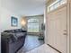 Inviting living room boasts wood floors, a large window, and comfortable gray couches at 5852 Stafford Springs Trl, Orlando, FL 32829