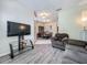 Comfortable living room leading into dining area, featuring hardwood floors and neutral decor at 5852 Stafford Springs Trl, Orlando, FL 32829