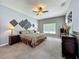 Serene main bedroom with plush carpeting, decorative wall art, and ample natural light at 5852 Stafford Springs Trl, Orlando, FL 32829