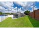 This backyard features a screened in in-ground pool, covered patio, and a well-manicured lawn at 603 Cypress Tree Ct, Orlando, FL 32825