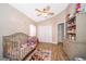 bedroom showcasing a crib, princess decor, ceiling fan, and wood-look floors at 603 Cypress Tree Ct, Orlando, FL 32825