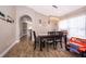 Dining area featuring an industrial light fixture, wood floors, and an arched doorway at 603 Cypress Tree Ct, Orlando, FL 32825