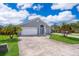 Charming single Gathering home featuring a blue door, landscaped front yard and a two car garage at 603 Cypress Tree Ct, Orlando, FL 32825