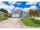 Charming single Gathering home featuring a blue door, landscaped front yard and a two car garage at 603 Cypress Tree Ct, Orlando, FL 32825