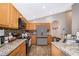 Well-lit kitchen boasts wooden cabinets, stainless steel appliances, and granite countertops at 603 Cypress Tree Ct, Orlando, FL 32825
