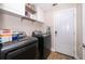 Laundry room with modern appliances, wood-look floors, storage, and access to the exterior at 603 Cypress Tree Ct, Orlando, FL 32825