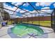 This screened in in-ground pool features string lights and lounge chairs for relaxing at 603 Cypress Tree Ct, Orlando, FL 32825