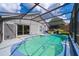 This screened in in-ground pool features string lights and a sliding glass door to the home at 603 Cypress Tree Ct, Orlando, FL 32825