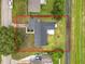 Aerial view of the L-shaped home with a dark gray roof, green yard and a small patio in the backyard, outlined in red at 609 Brockway Ave, Orlando, FL 32807