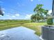 View of the home's backyard showing a large grassy area, patio, and mature shade trees at 609 Brockway Ave, Orlando, FL 32807