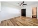 This bedroom has wood-look floors, fresh white paint, closet, dark trim and door and adjoining bathroom at 609 Brockway Ave, Orlando, FL 32807