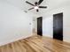 Spacious bedroom with a ceiling fan, hardwood flooring, and dark-painted doors at 609 Brockway Ave, Orlando, FL 32807
