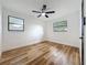 This bright bedroom features wood-look floors, two windows, fresh white paint and modern ceiling fan at 609 Brockway Ave, Orlando, FL 32807