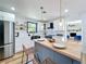 Bright kitchen features stainless steel appliances, white cabinets, wood countertops and bar stool seating at 609 Brockway Ave, Orlando, FL 32807