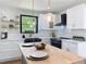 Bright kitchen features stainless steel appliances, white cabinets, wood countertops and an island at 609 Brockway Ave, Orlando, FL 32807