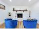 Charming living room featuring a white brick fireplace, wooden mantel and comfortable blue seating at 609 Brockway Ave, Orlando, FL 32807