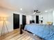Modern bedroom with wood floors, dark wood doors, and a glimpse into the kitchen at 609 Brockway Ave, Orlando, FL 32807