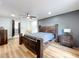 Comfortable bedroom with wooden floors, a large bed, a gray accent wall, and wood furnishings at 609 Brockway Ave, Orlando, FL 32807