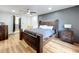 Relaxing main bedroom featuring hardwood floors, a stylish bed, a gray accent wall and wooden furniture at 609 Brockway Ave, Orlando, FL 32807