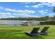 Lawn with lounge chairs overlooks the serene lake, providing a tranquil retreat for relaxation at 641 Virginia Dr, Winter Park, FL 32789